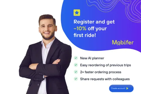 Smiling man in a suit beside a promo panel