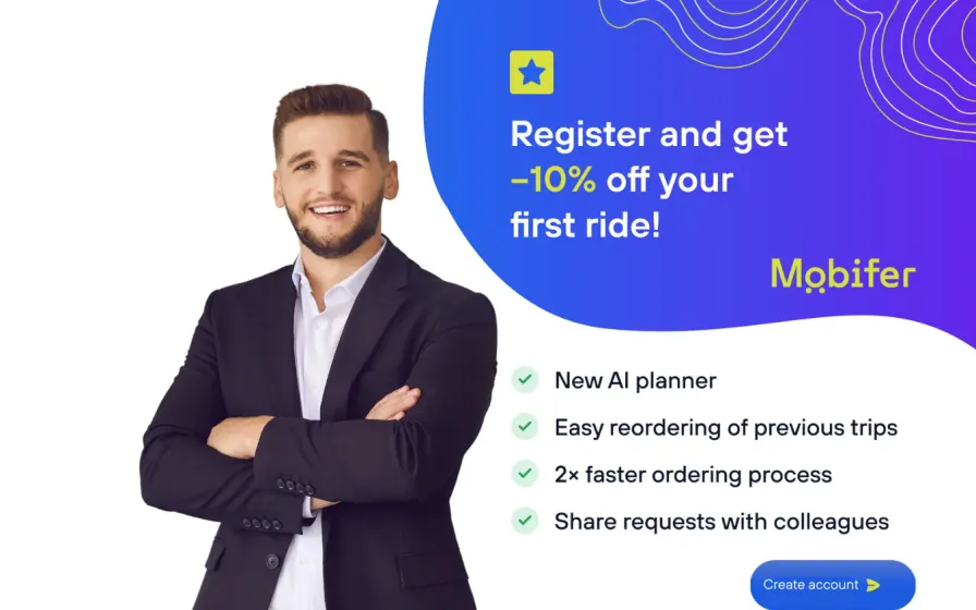 Smiling man in a suit beside a promo panel