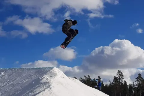 Snowboarder mid-air above a snow jump