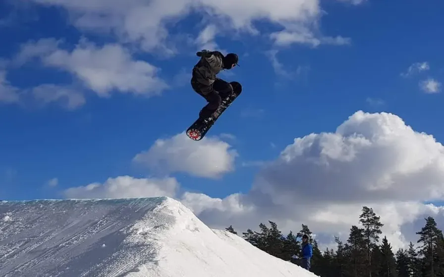 Snowboarder mid-air above a snow jump