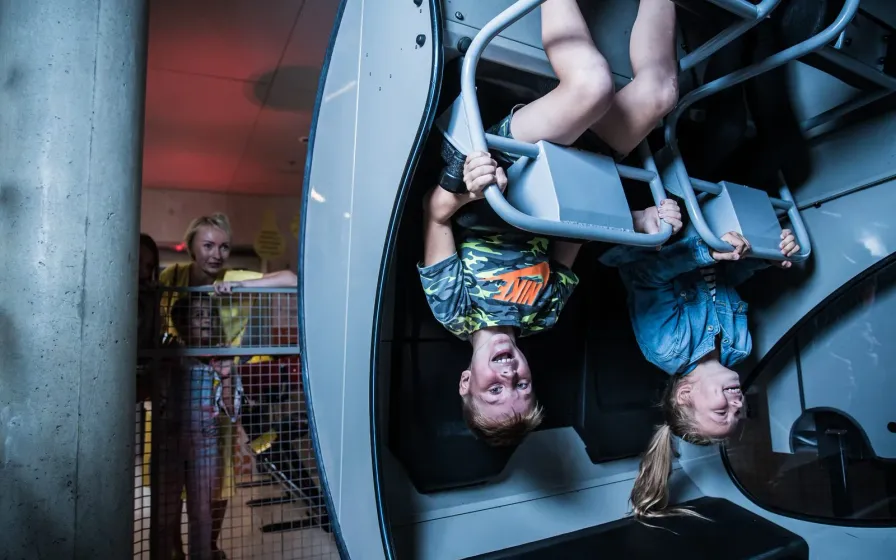 Children hanging upside down on play bars