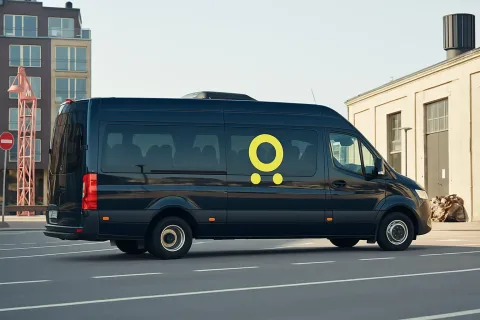 Black van with yellow logo decal on a street