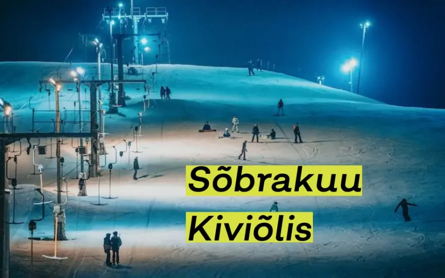 Suusatajad valgustatud õhtusel nõlval