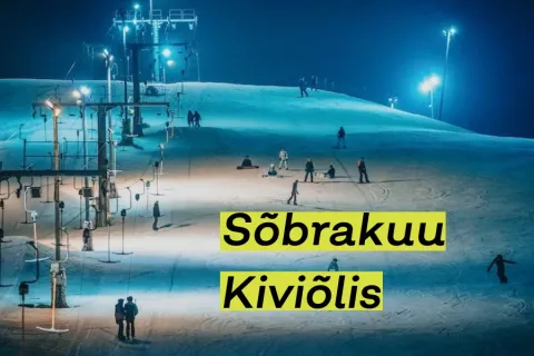 Suusatajad valgustatud õhtusel nõlval